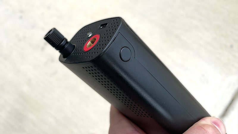 Close-up of the Airmoto tire inflator's air hose connector and control button