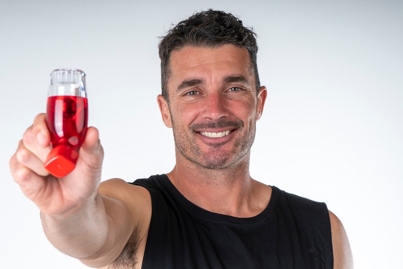 Hand holding the red AirPhysio Sports OPEP device