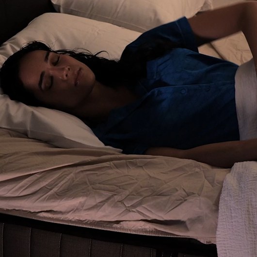 Person sleeping on a bed made with the Bed Bunny fitted sheet at night
