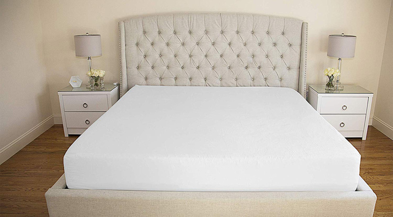 A smooth, tightly fitted white sheet on a made bed after using the Bed Scrunchie