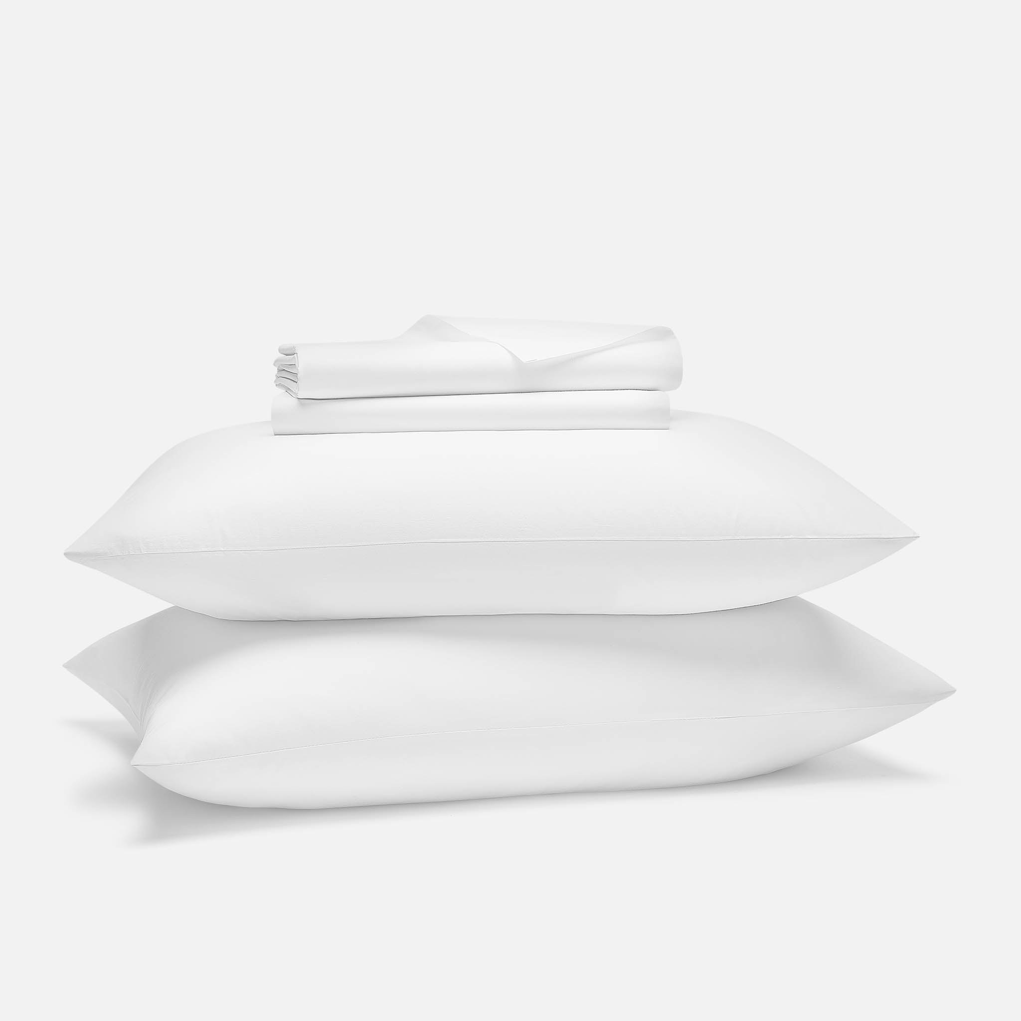 Brooklinen Classic Percale sheet set folded with two white pillows