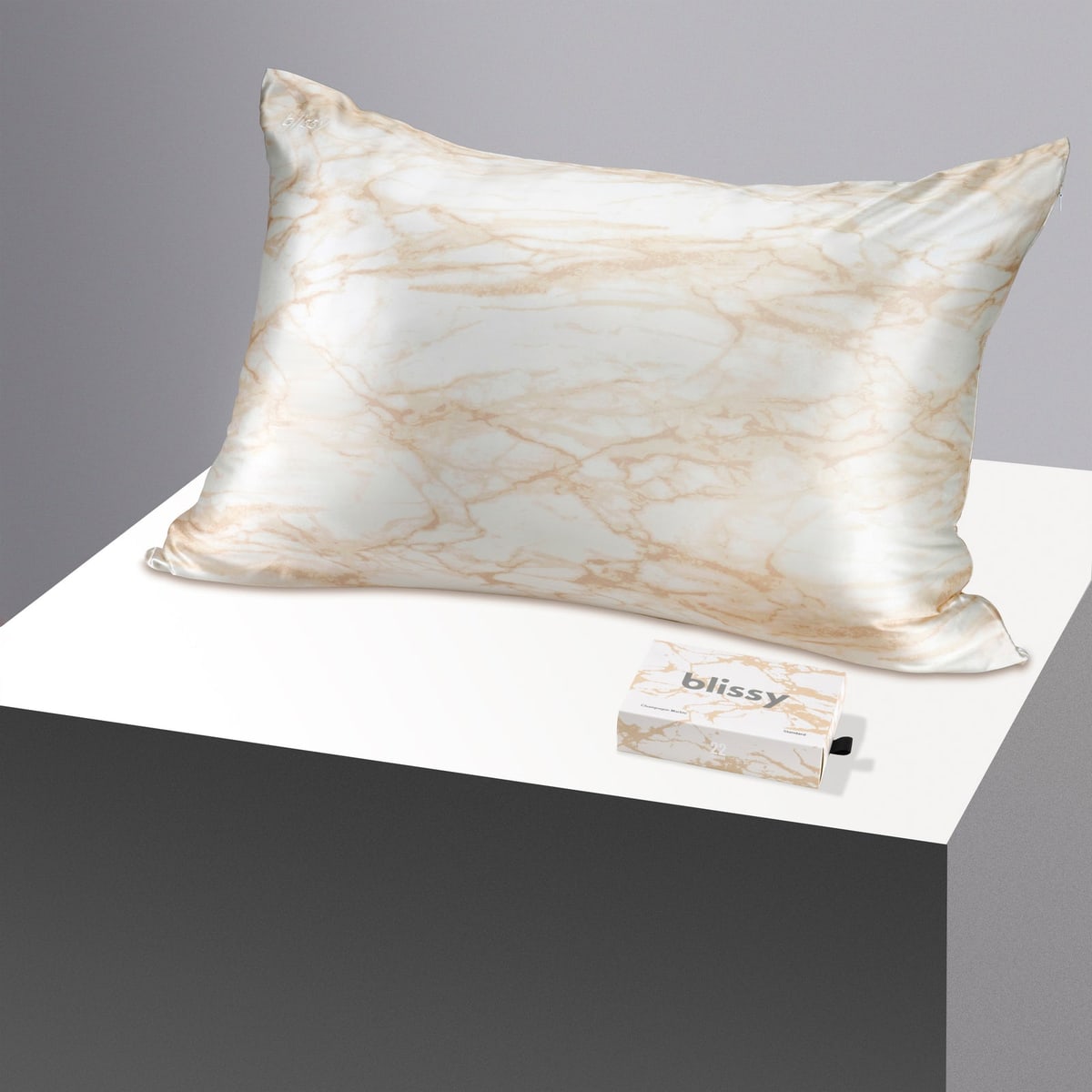 Blissy champagne marble mulberry silk pillowcase beside its box