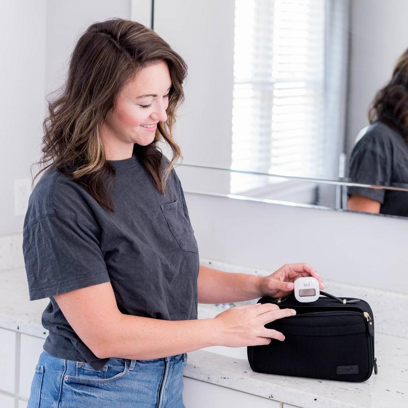 Bril UV-C toothbrush sanitizer being packed into a travel toiletry bag