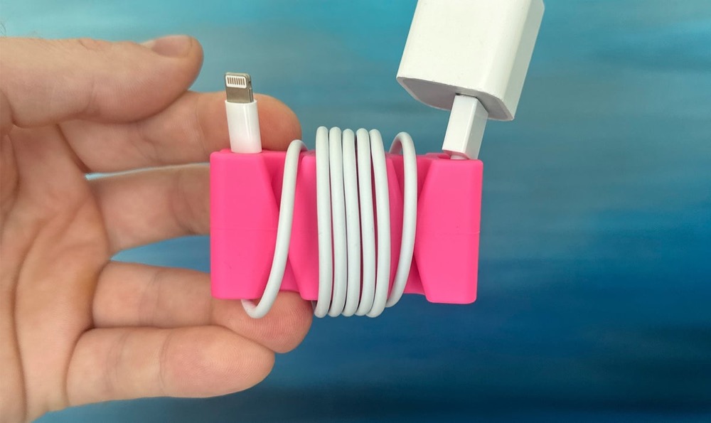 CordBrick in pink with a Lightning charging cable wrapped around it for travel