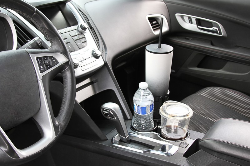 CupStation expandable cup holder holding a large water bottle and a drink in a car console
