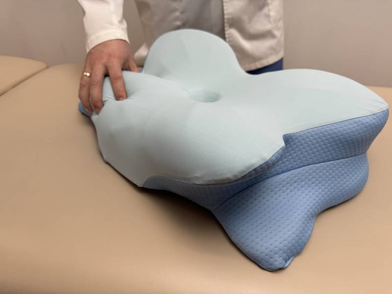 A hand pressing into the Derila Ergo memory foam to show how the surface compresses