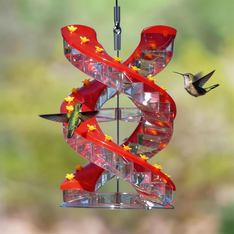 DNA Helix hummingbird feeder hanging in a garden with two hummingbirds feeding at its spiral of flower ports