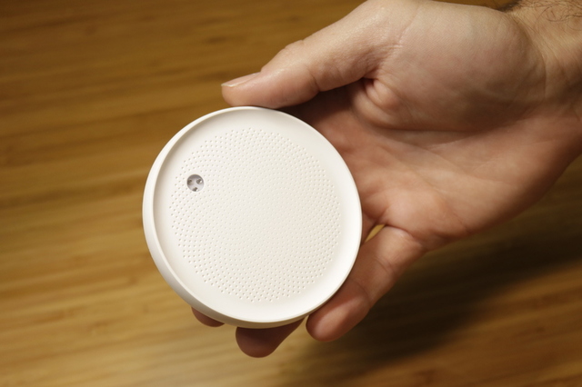 Dodow sleep aid device held in a hand, showing its compact puck shape