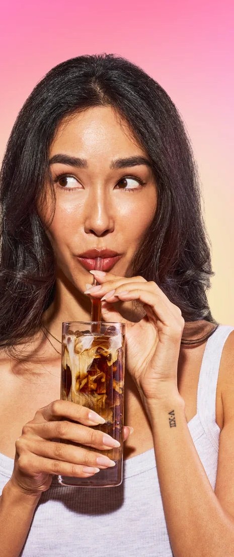 Person drinking an iced Everyday Dose coffee