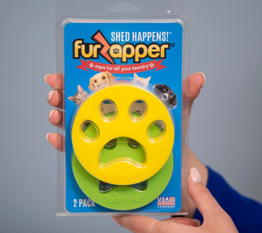 A hand holding the FurZapper two-pack retail package