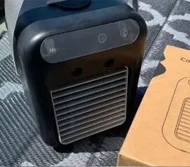 Glacier Breeze personal cooler sitting on a bedroom nightstand next to its box