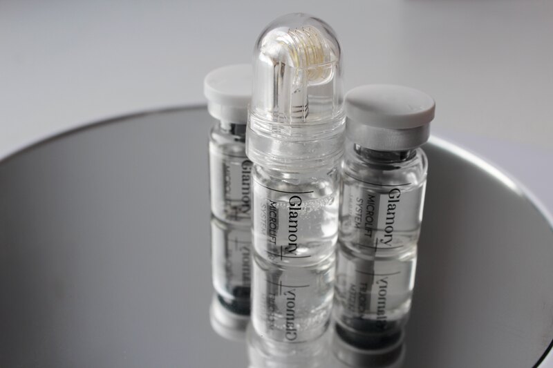 Three Glamory MicroLift System serum vials with the micro-infusion roller head