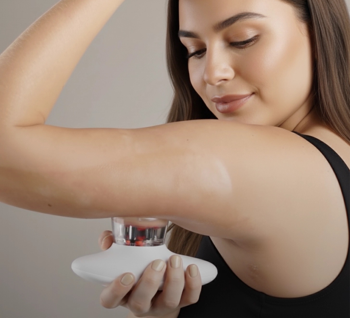 Person using the Glokore IPL Body Sculptor on the upper arm with the red-light cup head