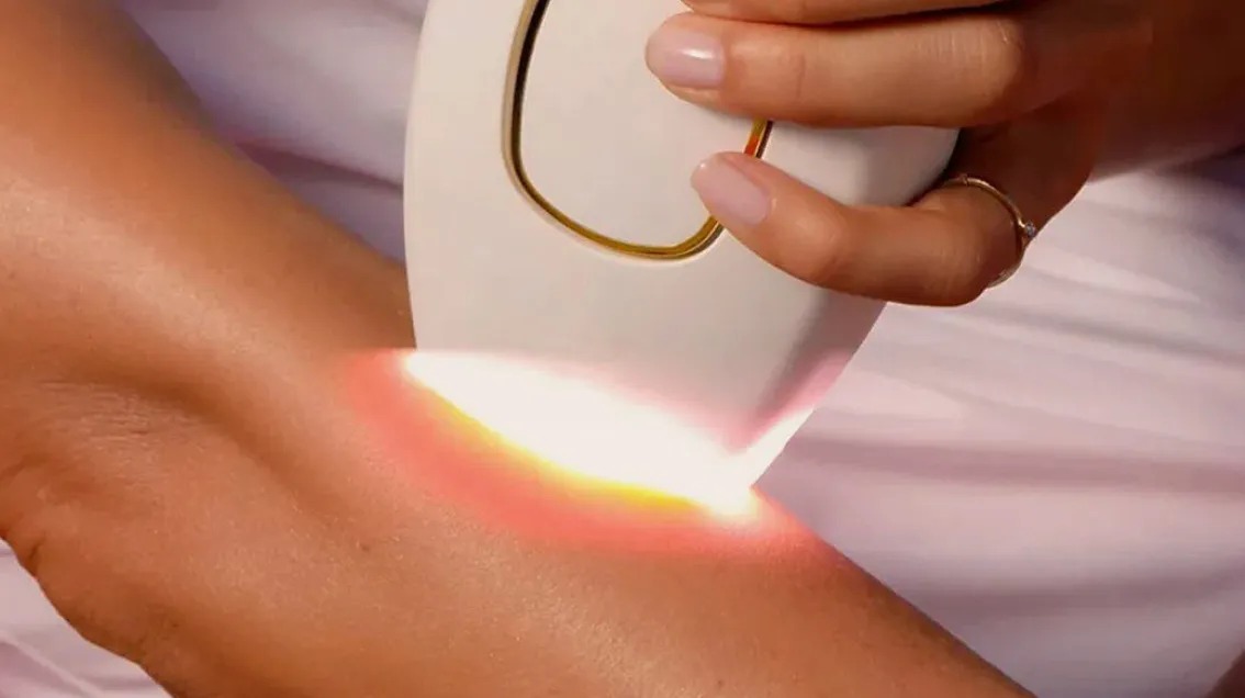 The Glokore IPL hair remover firing a pulse of light on skin