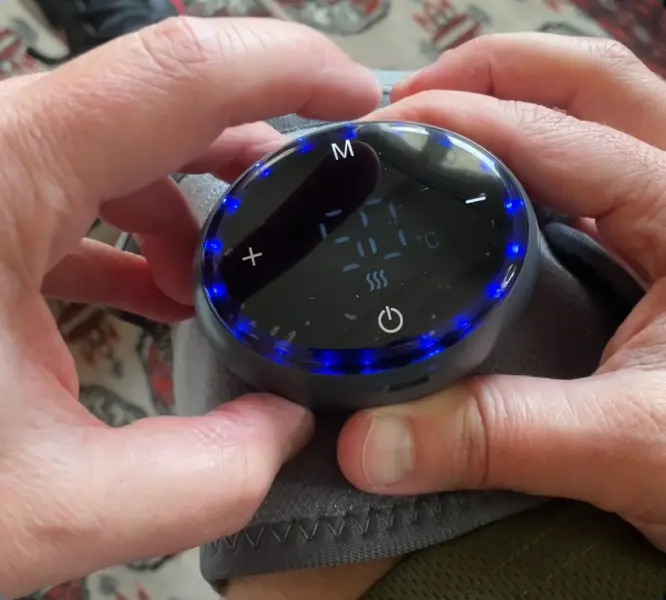 Close-up of a person adjusting the Glokore Knee Massager control dial