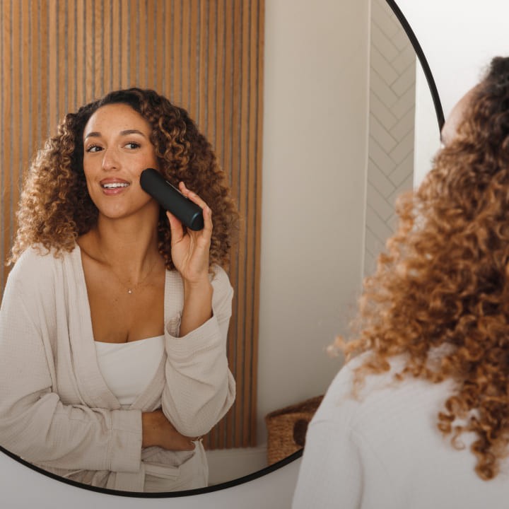 Person using the Glokore Transformer Wand at a bathroom mirror