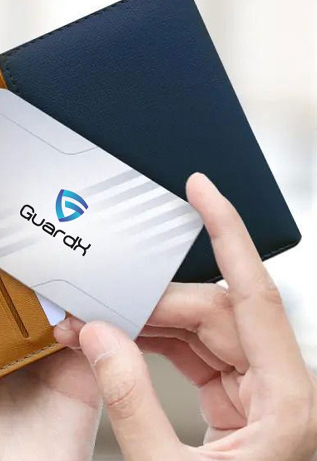 A GuardX RFID blocking card held next to a wallet