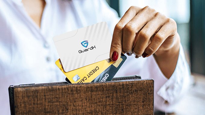 GuardX RFID blocking card being slipped into a wallet card slot