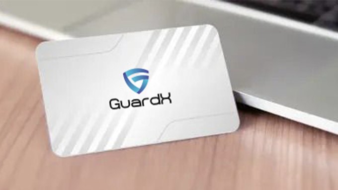 GuardX RFID blocking card resting on a desk beside a wallet
