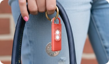 Halo Siren personal safety alarm clipped to the strap of a bag
