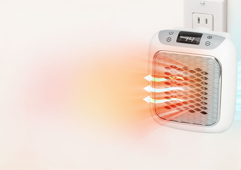 HeatWell plug-in ceramic heater with a digital temperature display showing 74, plugged into a wall outlet