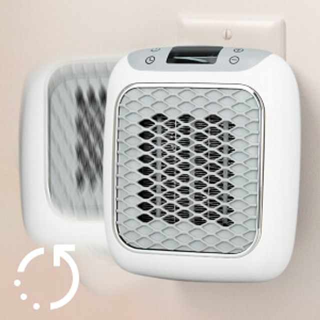 Close-up of the HeatWell ceramic heater front grille plugged into a wall outlet