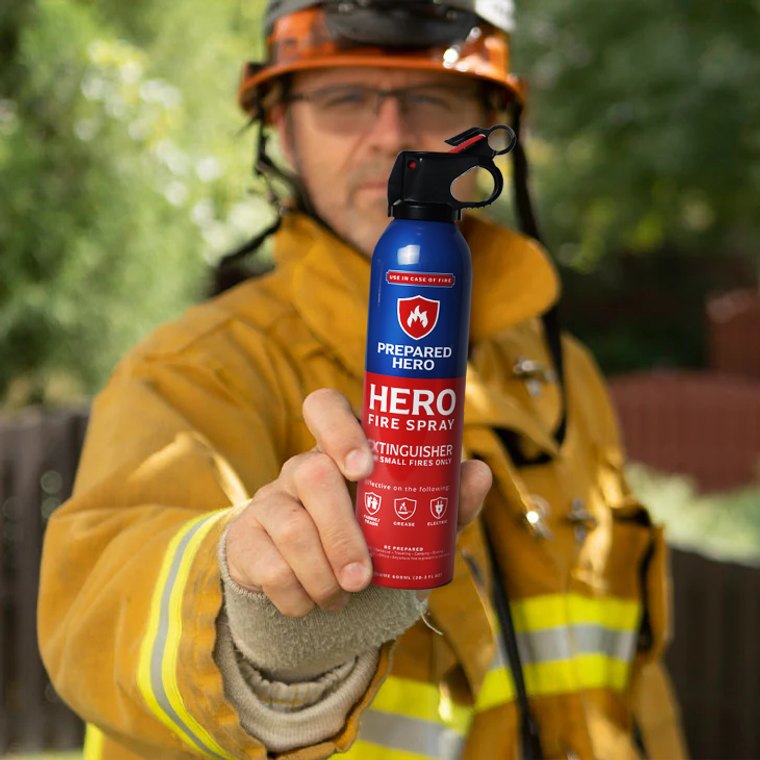 Firefighter holding a can of Hero Fire Spray aerosol fire suppressant outdoors