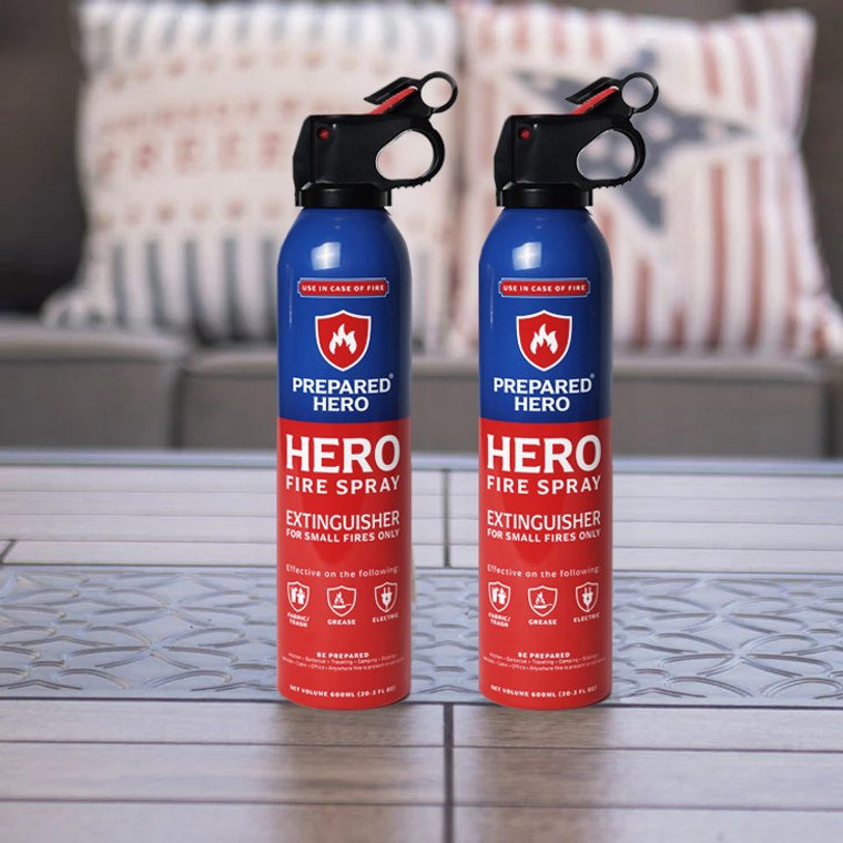 Two Hero Fire Spray cans standing on a patio table