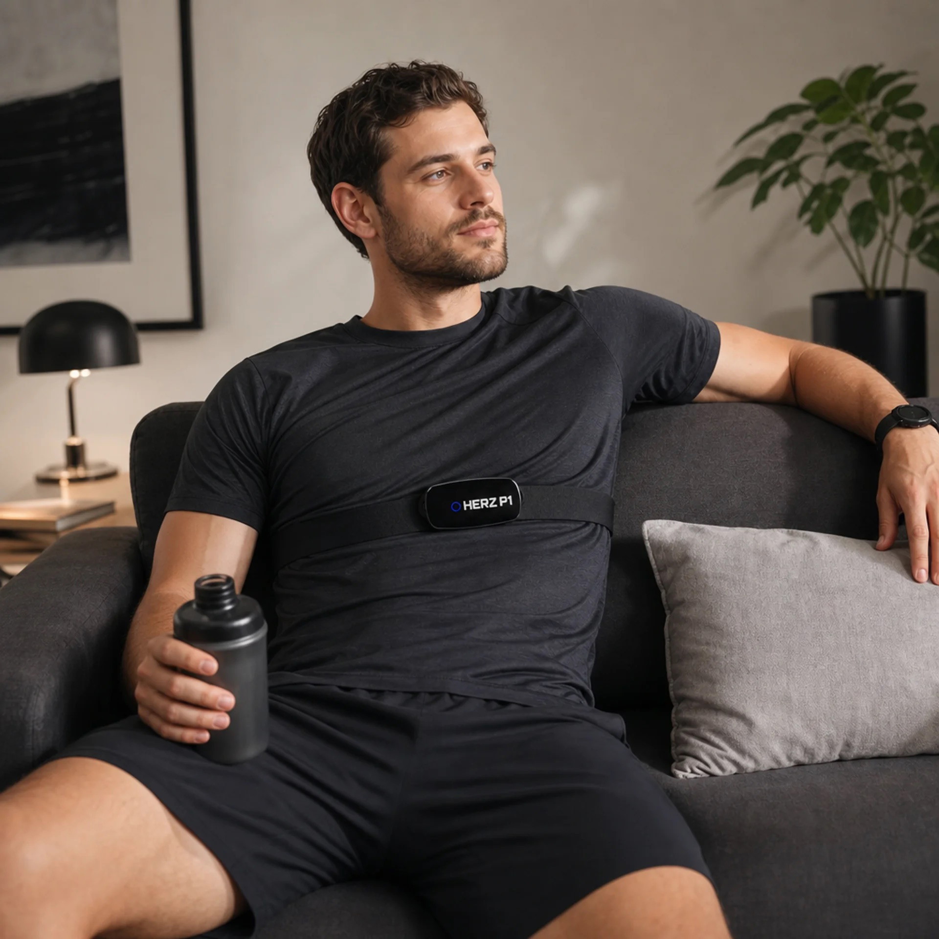 Man relaxing on a couch wearing the Herz P1 chest strap
