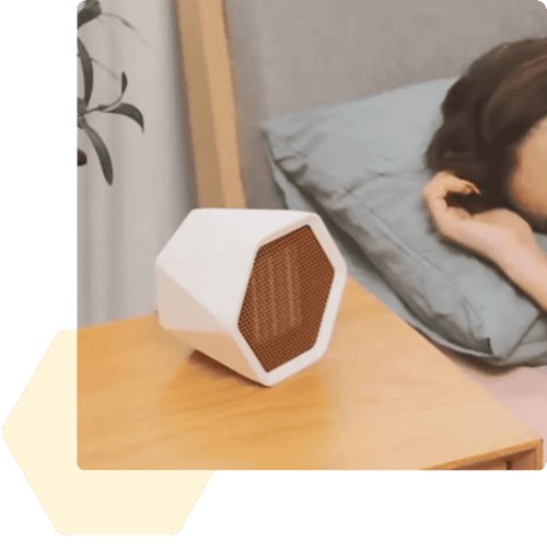HexaHeat compact ceramic heater running on a bedside nightstand next to a bed
