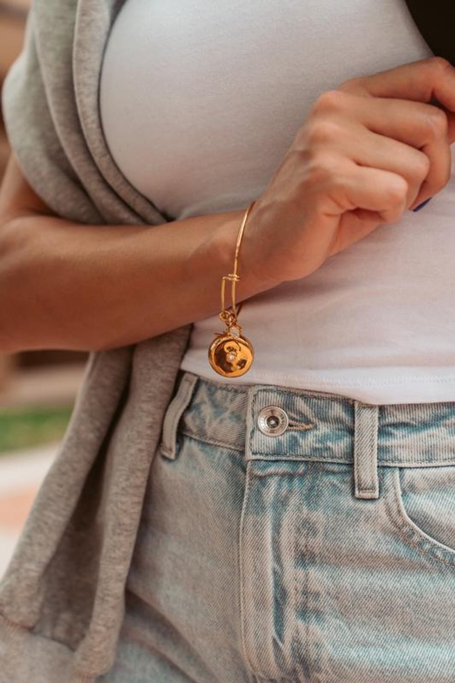 Close-up of the invisaWear smart safety charm worn as a bracelet on a wrist