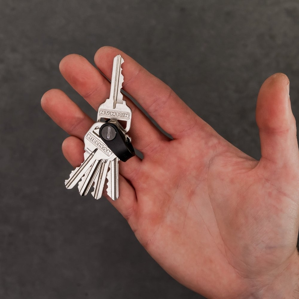 A KeySmart key organizer held in an open palm, showing how compact the stacked keys are