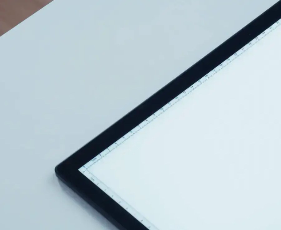 Close-up of the Lite Sketch Lightpad corner showing the built-in ruler markings along the illuminated edge