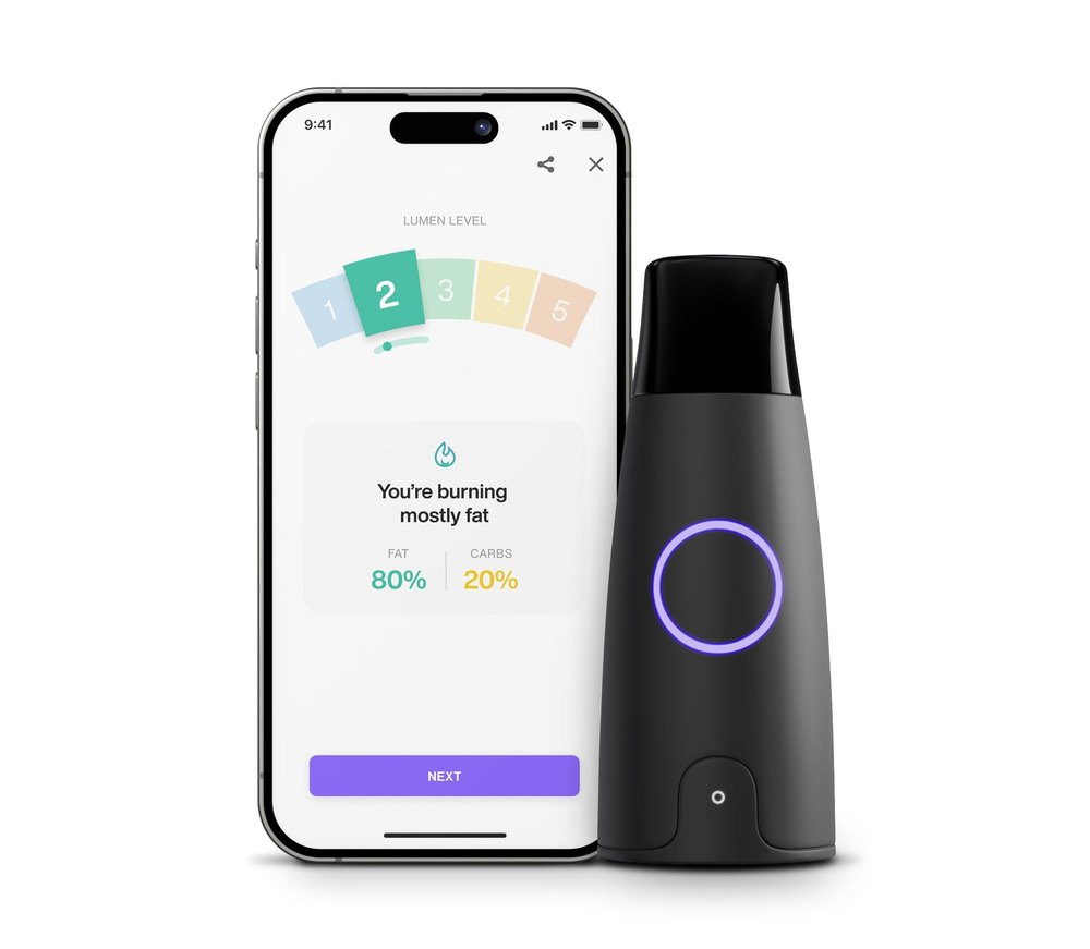 Lumen metabolism tracker beside a phone showing the app's Lumen Level reading and fat-versus-carb burning result