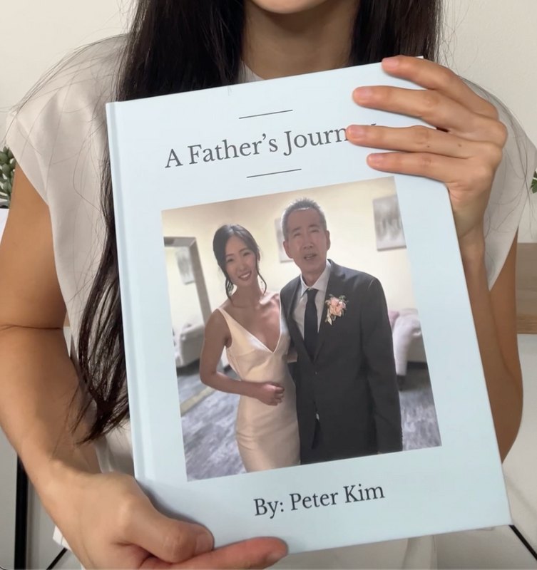 Person holding a light blue Memorygram 'A Father's Journey' legacy book