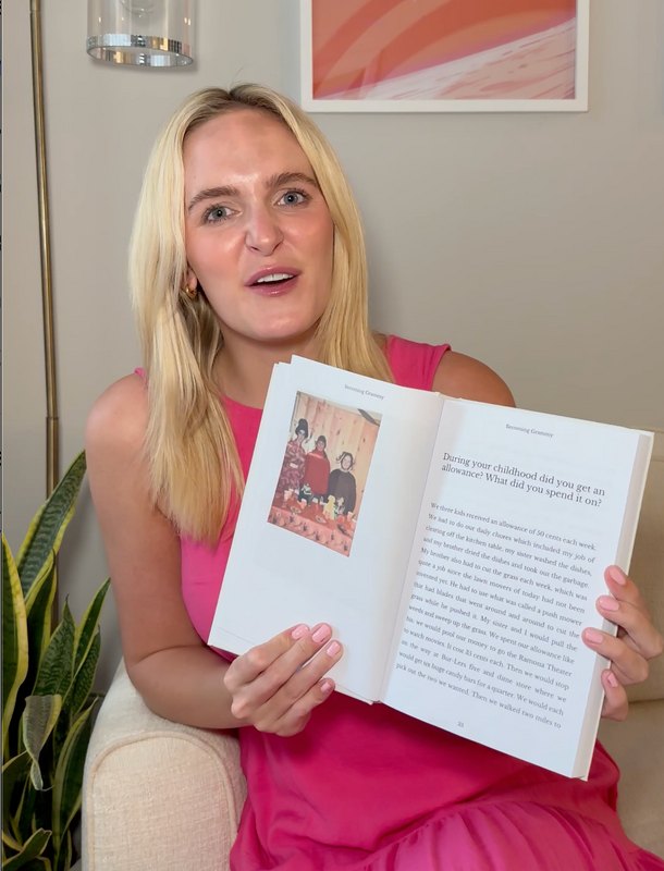 Person holding an open Memorygram legacy book to a childhood-memory prompt page