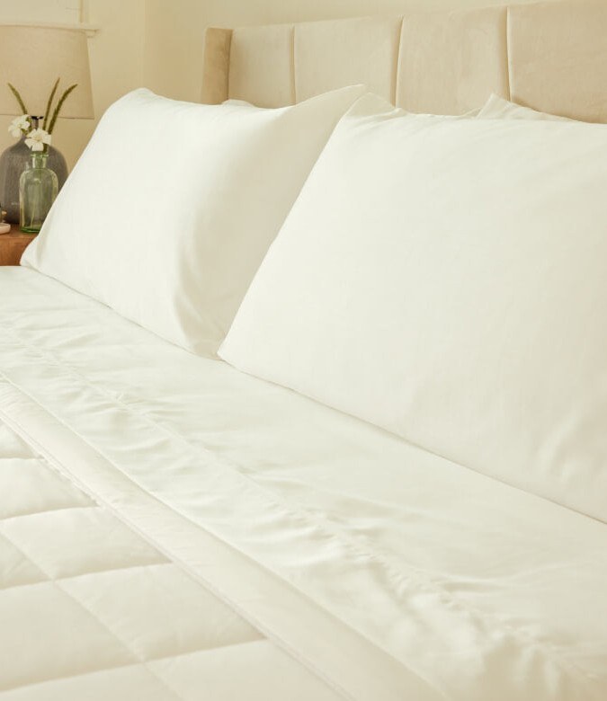 Miracle Made Cooling Comforter in white on a made bed in a bedroom