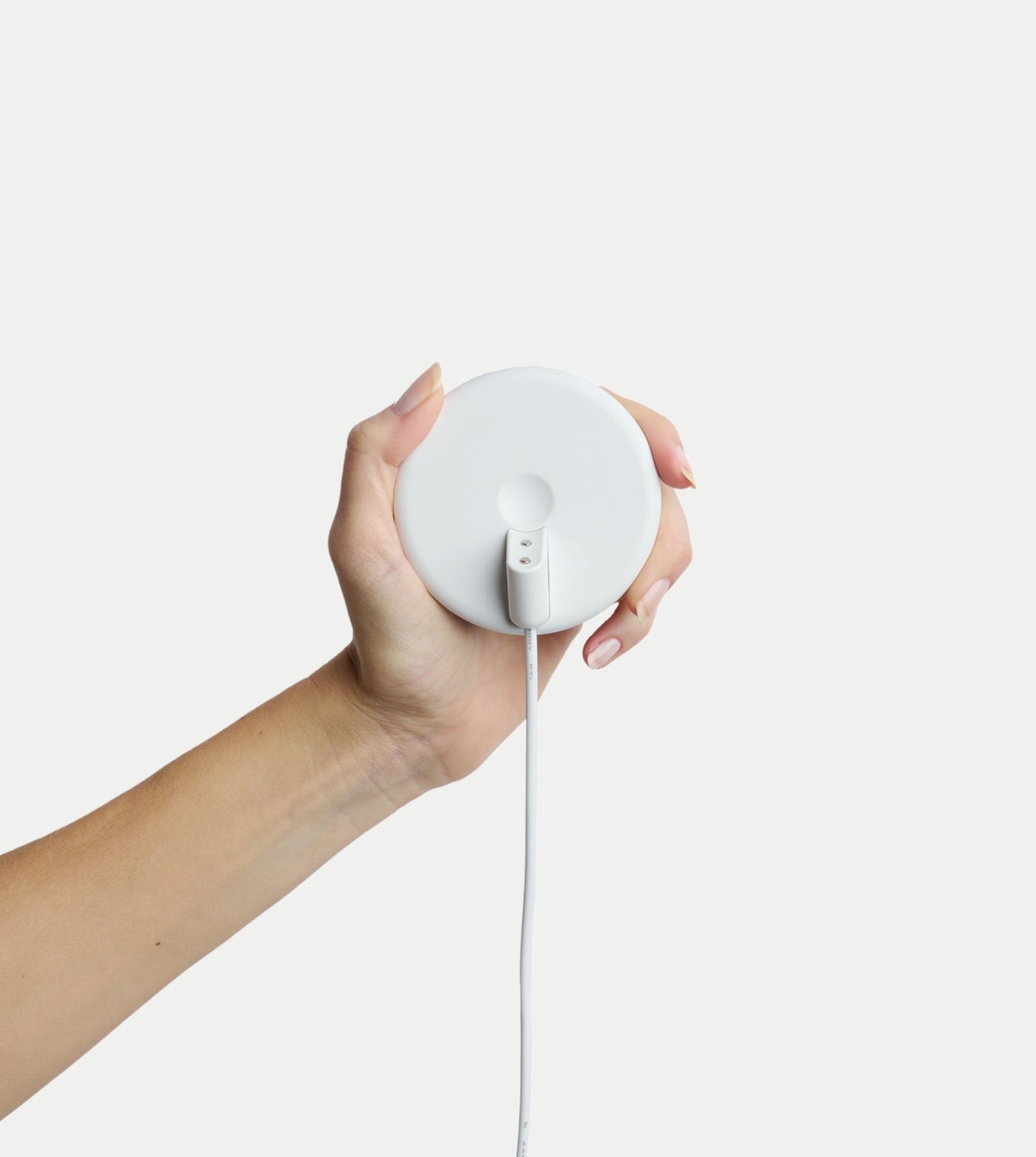 Moonbird breathing coach magnetic charging stand held in a hand