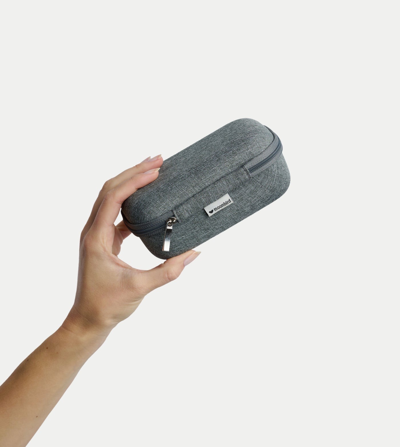 Moonbird breathing device in its compact travel case held in one hand