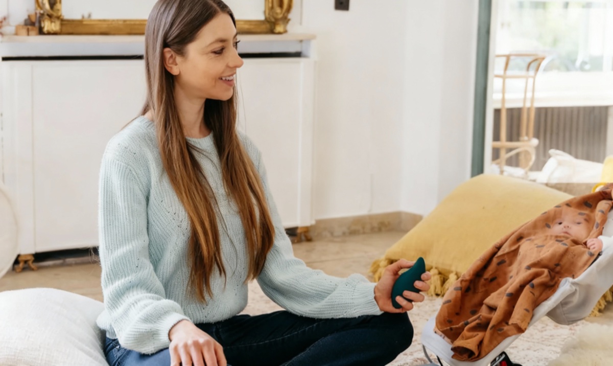 Person holding the Moonbird breathing coach while sitting with a baby