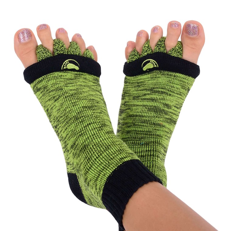 A pair of green My Happy Feet foot alignment socks worn on feet with the toe separators visible