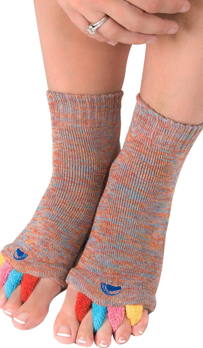 Feet wearing My Happy Feet alignment socks with the person seated, toes spread by the colorful separators