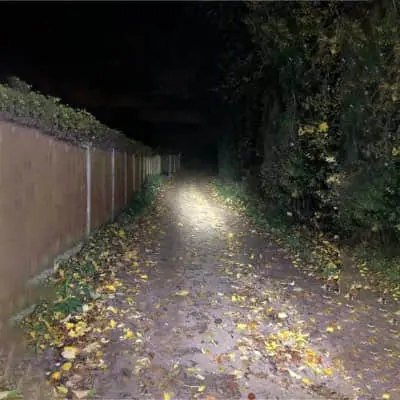 Night Spark flashlight beam lighting up a dark path at night