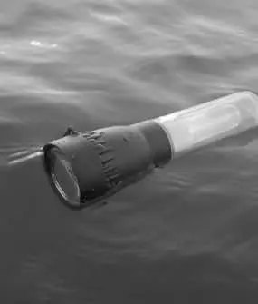 Night Spark flashlight partially submerged in water, showing its IPX7 water resistance