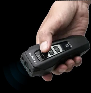 Hand holding the NoBark Ultra ultrasonic anti-barking device, thumb on the mode buttons