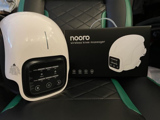Nooro Knee Massager device next to its retail box