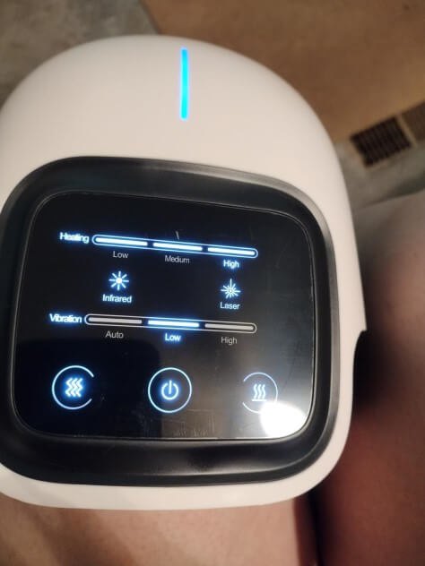 Nooro Knee Massager lit touchscreen control panel showing heat, light, and vibration settings