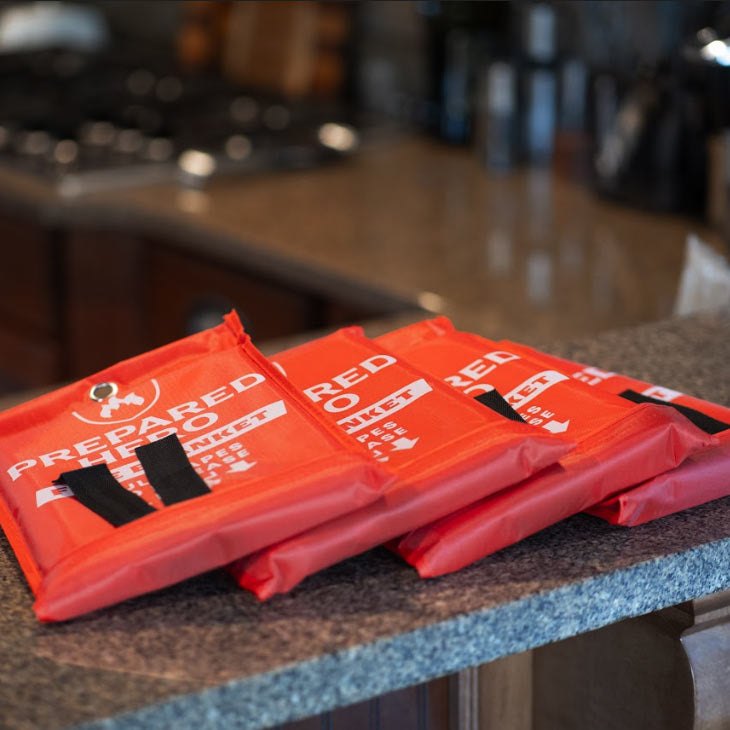 Prepared Hero fire blanket pouches resting on a kitchen counter near the stove