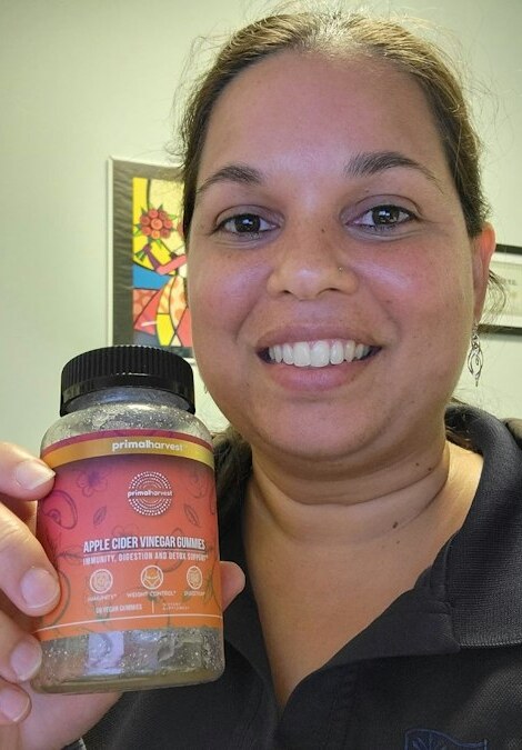 Person holding a bottle of Primal Harvest ACV Gummies