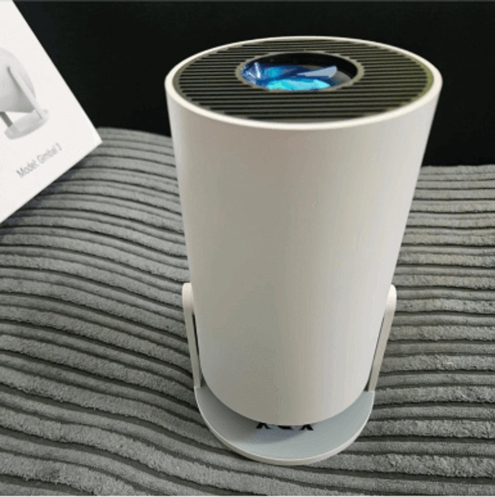 The Projector Go portable LED projector on its swivel base next to its box